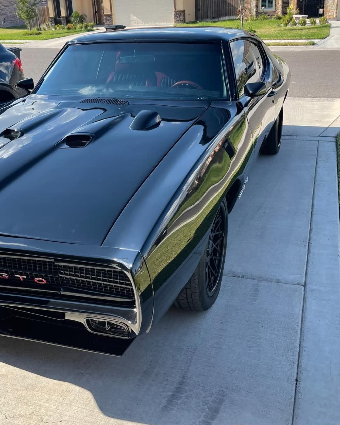 Black 1969 Pontiac GTO with fresh window tint, parked in the sun